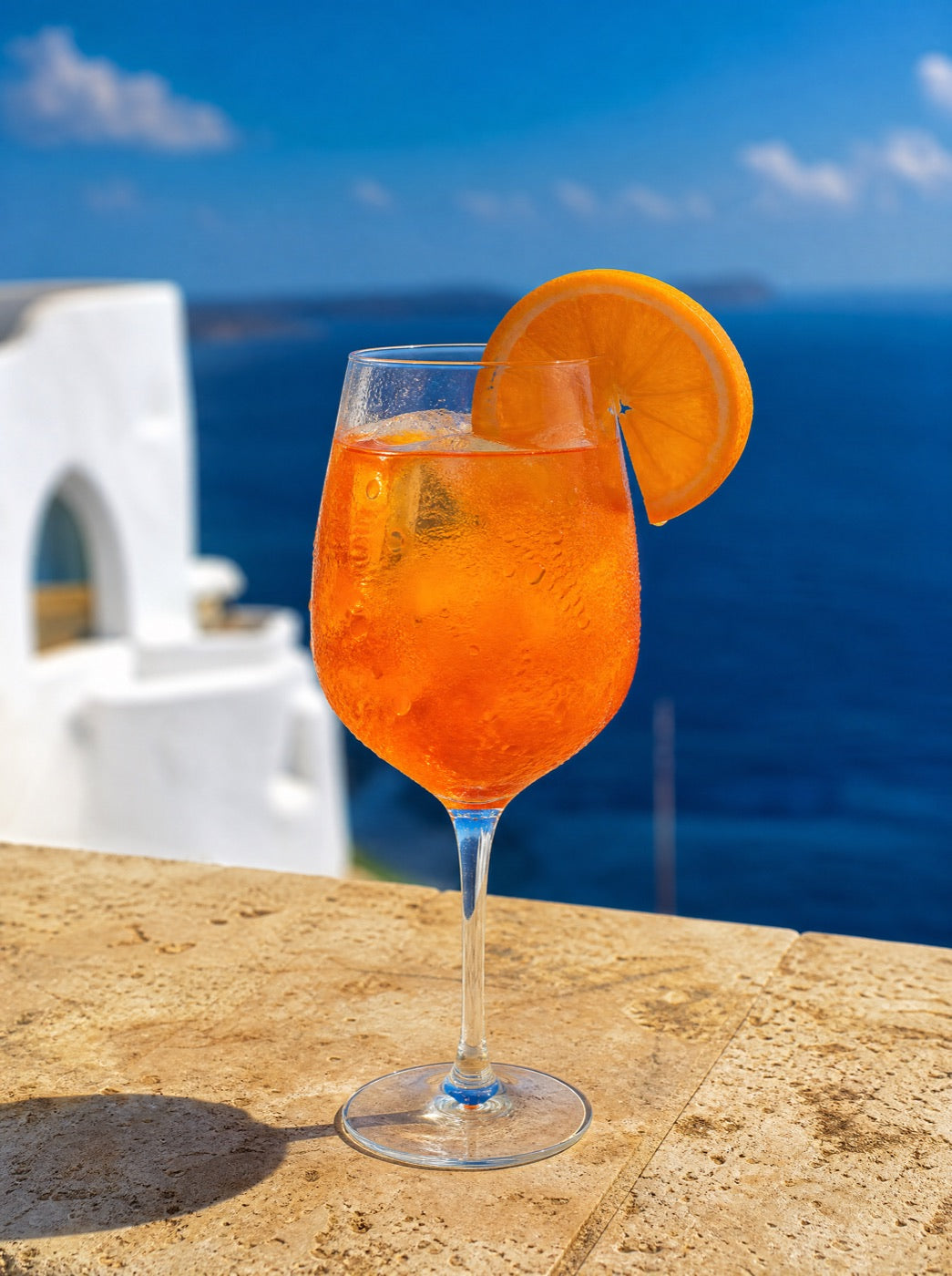 An orange spritz sweating on a stone table